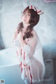 A woman in a white and red lingerie posing in a bathtub.