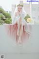 A woman in a wedding dress sitting on a ledge.