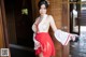 A woman in a red and white dress posing for a picture.