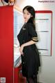 A woman standing in front of a red refrigerator.