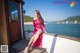 A woman in a pink dress sitting on a boat.