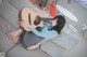 A woman sitting on a couch playing a guitar.