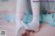 A close up of a person wearing white socks on a bed.