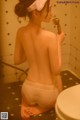 A woman in a white panties is taking a shower.