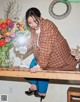 A woman sitting on top of a wooden table holding a cell phone.