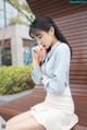 A woman sitting on a bench smoking a cigarette.