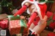 A woman in a santa claus outfit holding a present.