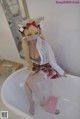 A woman sitting in a bathtub with a cat ears headband.