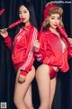 A couple of women in red outfits posing for a picture.