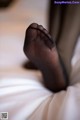 A close up of a person's feet in black stockings.