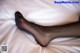 A woman's legs in black stockings laying on a bed.