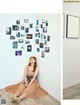 A woman sitting on the floor in front of a wall with pictures on it.