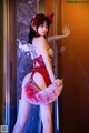 A woman in a red lingerie posing for a picture.