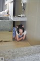 A woman laying on the floor in a bathroom.