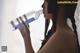 A woman drinking water from a plastic bottle.