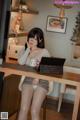 A woman sitting at a desk with a laptop computer.