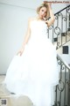 A woman in a wedding dress standing on a staircase.