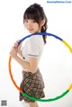 A young woman holding a hula hoop in her hands.