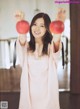 A woman holding two red apples in her hands.