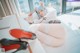 A woman sitting on top of a white couch next to a laptop.