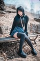 A woman sitting on a bench in a park.