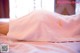 A pink towel with chinese writing on it laying on a bed.