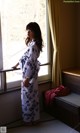 A woman standing in front of a window in a room.