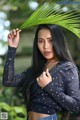 A woman holding a palm leaf in her hand.