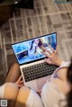 A woman sitting on the floor using a laptop computer.