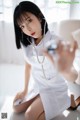 A woman in a white lab coat holding a stethoscope.