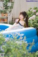 A woman sitting in an inflatable pool in a garden.