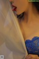 A woman in a blue lingerie with a veil over her head.