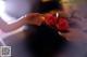 A woman holding a tray with two red roses on it.