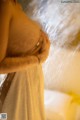 A woman in a towel is taking a shower.