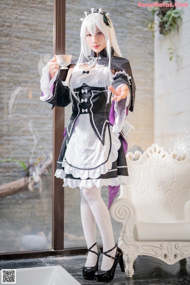 A woman dressed in a maid outfit holding a cup of coffee.