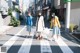 Three young women walking across a crosswalk carrying shopping bags.