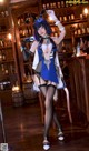 A woman in a blue and white outfit posing in front of a bar.