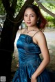 A woman in a blue dress posing for a picture.