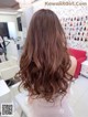 A woman with long brown hair in a salon.