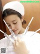 A woman in a white lab coat holding a syringe.