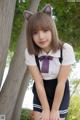 A young woman in a school uniform posing for a picture.