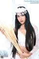 A woman in a white lingerie holding a bunch of wheat.