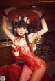 A woman in a red lingerie posing in a kitchen.