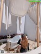 A woman sitting in a bathtub under a gazebo.