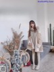 a woman standing in front of a couch wearing a fur coat