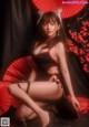 A woman in a black and red lingerie posing for a picture.