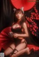 A woman in a black and red lingerie holding a red umbrella.