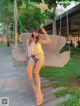 A woman sitting on a swing in a park.