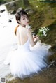 A woman in a white dress holding a bouquet of flowers.