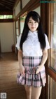 A young woman in a school uniform posing for a picture.